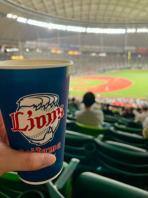 ビールを持って野球観戦している写真